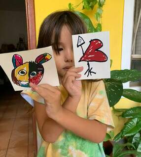 Caio Hiro, de 5 anos, segura dois desenhos que viraram adesivos. (Foto: Arquivo pessoal)