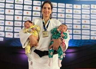 Atleta Camila Yamakawa com os filhos Ayla e Akira nos braços após ser campeã. (Foto: Arquivo Pessoal)