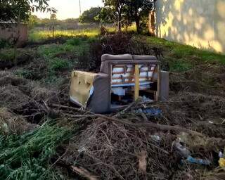 No Bairro Moreninhas, morador reclama de terreno onde são descartados restos de marmitas e móveis velhos. (Foto: Direto das Ruas)