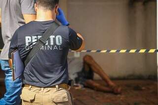 Perito criminal fazendo os primeiros levantamentos no local onde a vítima foi encontrada morta (Foto: Henrique Kawaminami) 