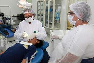 Servidores municipais de odontologia durante procedimento (Foto: Divulgação/PMCG)