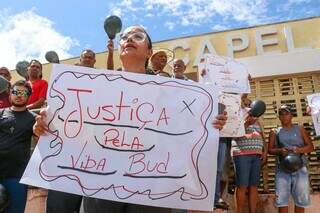 Mônica segura cartaz que pede justiça pela vida de &#34;Bud&#34;, apelido da vítima. (Foto: Henrique Kawaminami)