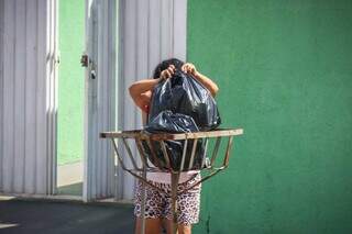 Claudelice dos Santos cumpre rotina de descartas dois sacos de lixo a cada dia de coleta. (Foto: Henrique Kawaminami)