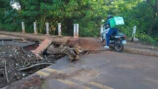 Mesmo com ponte interditada, motociclista passa por trecho destruído da Rua Rivaldi Albert (Foto: Thays Schneider)