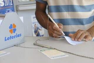 Apostador preenche canhoto de apostas da Mega-Sena em agência lotérica. (Foto: Arquivo)
