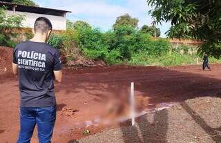 Corpo foi encontrado no meio da lama em rua da região norte de Dourados (Foto: Adilson Domingos)