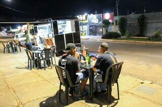 Na calçada, clientes aproveitam o cachorro-quente da noite. (Foto: Juliano Almeida)