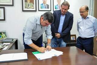 Governador Eduardo Riedel assinando contrato ao lado do secretário da Casa Civil, Eduardo Rocha; e do vice-governador José Carlos Barbosa (Foto: Max Arantes)