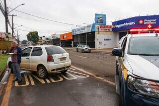 Arthur, condutor do Palio, conversa no telefone, enquanto carros batidos estão parados (Foto: Henrique Kawaminami)