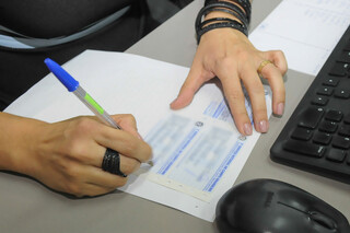 Funcionária de cartório assina documentação em Campo Grande. (Foto: Paulo Francis/Arquivo)