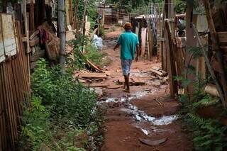 Morador caminhando por favela de Campo Grande (Foto: Henrique Kawaminami/Arquivo)