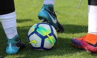 Jogador segura a bola com a chuteira em campo de futebol. (Foto: Fernando Torres/CBF)