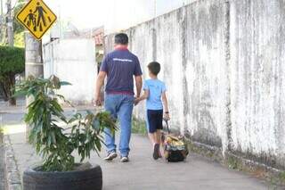 Vendedor levando filho de 8 anos embora após ataque. (Foto: Alex Machado)