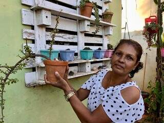 Rose mostra uma das plantas cultivadas no jardim de casa. (Foto: Jéssica Fernandes)