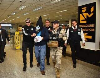Momento em que traficante chegava ao aeroporto com rosto coberto por capuz da Interpol (Foto: ABC Color)