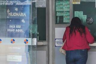 Mulher faz aposta em lotérica da Capital. (Foto: Marcos Maluf/Arquivo)