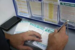 Apostador preenche canhoto de apostas da Mega-Sena em lotérica de Campo Grande. (Foto: Paulo Francis/Arquivo)