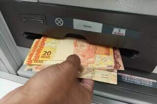 Homem sacando dinheiro em caixa eletrônico da Capital. (Foto: Campo Grande News/Arquivo )