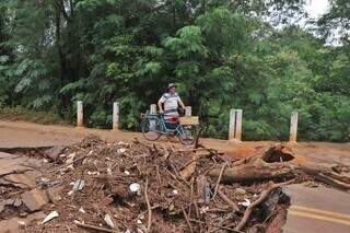 Vendedor ambulante Adaíno Calderan se arriscando em passagem na ponte (Foto: Paulo Francis)