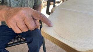 Marceneiro mostra detalhe da tábua de madeira encomendada. (Foto: Clara Farias)