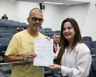 Alessandro recebendo a moção da deputada Mara Caseiro (PSDB) na Alems (Foto: Victor Chileno)