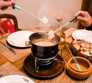 Casal comendo fondue na Cantina Romana (Foto: Reprodução/Instagram)