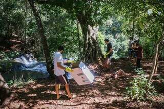 Voluntários recolhem lixo no entorno da Cachoeira do Ceuzinho. (Foto: Henrique Kawaminami)