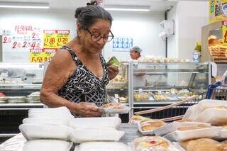 Afonsina com sabonete na mão e comprando rosca, em supermercado (Foto: Henrique Kawaminami)