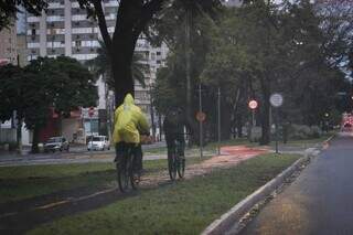 Ciclistas agasalhados na Avenida Afonso Pena na manhã desta terça-feira, feriado em Campo Grande (Foto: Henrique Kawaminami) 