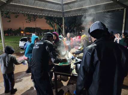 Moradores de comunidade pobre recebem roupas e sopa em noite de frio