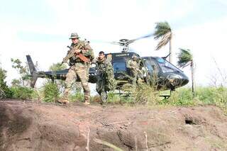 Agentes descem de helicóptero da PF em área de cultivo de maconha na fronteira (Foto: Divulgação)