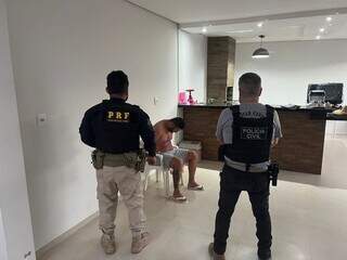 Agentes da Polícia Civil e da PRF vigiam um dos pistoleiros, preso hoje cedo em Ji-Paraná (Foto: Divulgação)