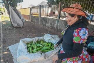 Maria mostra carregamento dos milhos que recebe para vender na rua. (Foto: Marcos Maluf)