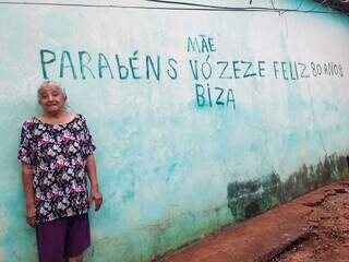 Dona Zezé ganhou parabéns estampado em parede de casa. (Foto: Aletheya Alves)