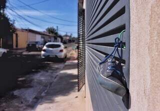 Tênis de uma das criançass que ficou para trás foi pendurado no portão vizinho. (Foto: Paulo Francis)