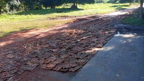 Sem conseguir colocar o carro na garagem de casa, morador cascalha a rua sozinho