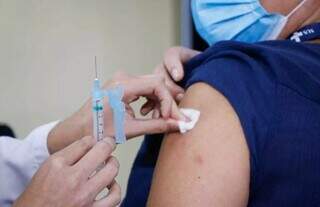 Profissional de saúde aplica dose de reforço da vacina que protege contra a covid-19. (Foto: Henrique Kawaminami)