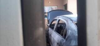 O carro estacionado na garagem da casa do casal completamente destruído (Foto: Ana Beatriz Rodrigues)