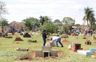 Familiares cuidando de túmulo no Cemitério Santo Amaro. (Foto: Paulo Francis)