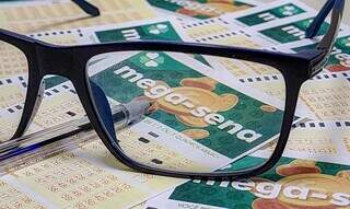 Bilhete de apostas da Mega-Sena é visto em lente de óculos. (Foto: Reprodução/Caixa)