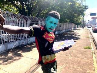 Na rua, Cristiano se fantasia como herói para vender o material. (Foto: Jéssica Fernandes)