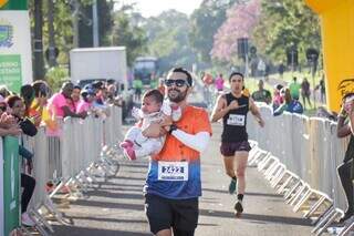 Flori da Cruz completando a prova com uma criança no colo (Foto: Henrique Kawaminami)