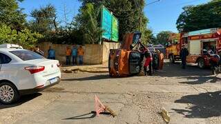 Bombeiro fazendo a retirada da vítima do Kwid tombado. (Foto: Clara Farias)