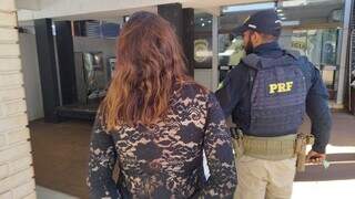 Mulher é conduzida por policial rodoviário após ser presa com maconha na BR-163 (Foto: Adilson Domingos)