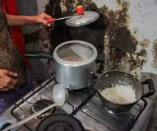 Mulher mostra arroz e feijão, o pouco para alimentar os filhos na favela Cidade de Deus, uma das mais conhecida na Capital (Foto: Marcos Maluf/Arquivo)