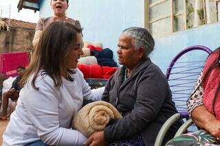 Prefeita Adriane Lopes entrega cobertor para Maria, de 82 anos. (Foto: Henrique Kawaminami)