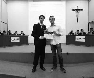 Matheus segura certificado de participação junto com colega após vencer júri simulado na faculdade (Foto: Diretório do Curso de Direito da UCDB)