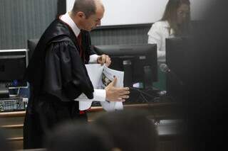 Promotor manuseia parte do processo, que também foi entregue aos jurados (Foto: Henrique Kawaminami)