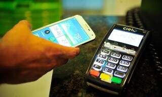 Consumidor realiza pagamento pelo aparelho celular. (Foto: Marcello Casal Jr./Agência Brasil)