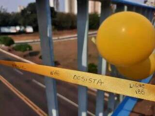 Dezenas de fitinhas foram amarradas na grade de pontilhão em Campo Grande, com mensagens de apoio. (Foto: Caroline Maldonado)